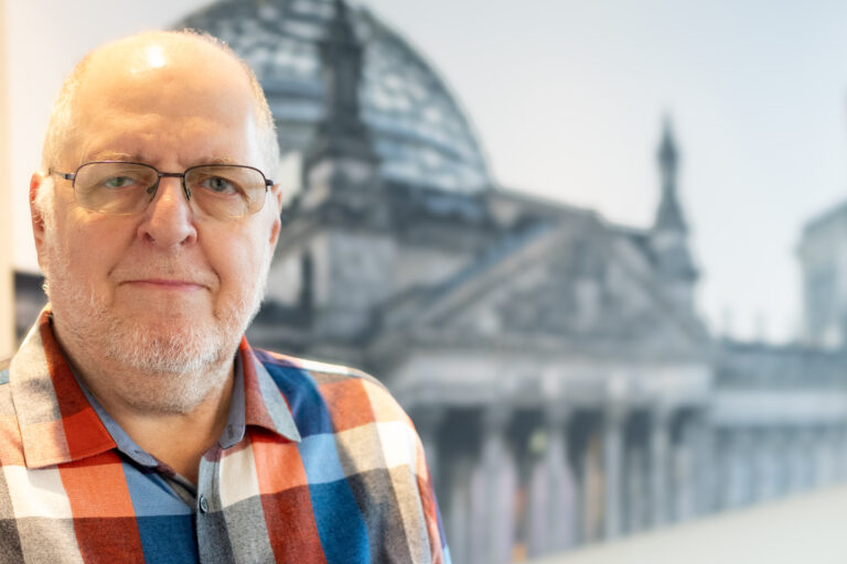 Porträtfoto von Franz Knieps vor dem Hintergrund des Reichstags